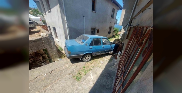 Kocaeli'de yokuş aşağı inen otomobil, iki evin arasına düştü