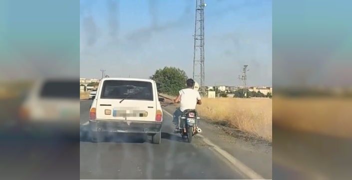 Otomobilin emniyet kemerine tutunan motosikletli: Siverek'te akılalmaz tehlike!